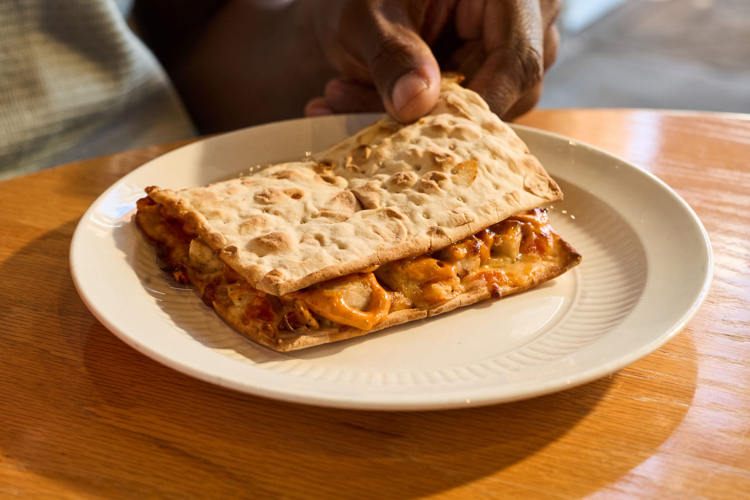 A wooden board with Smoothie King’s Chicken Flatbread on top