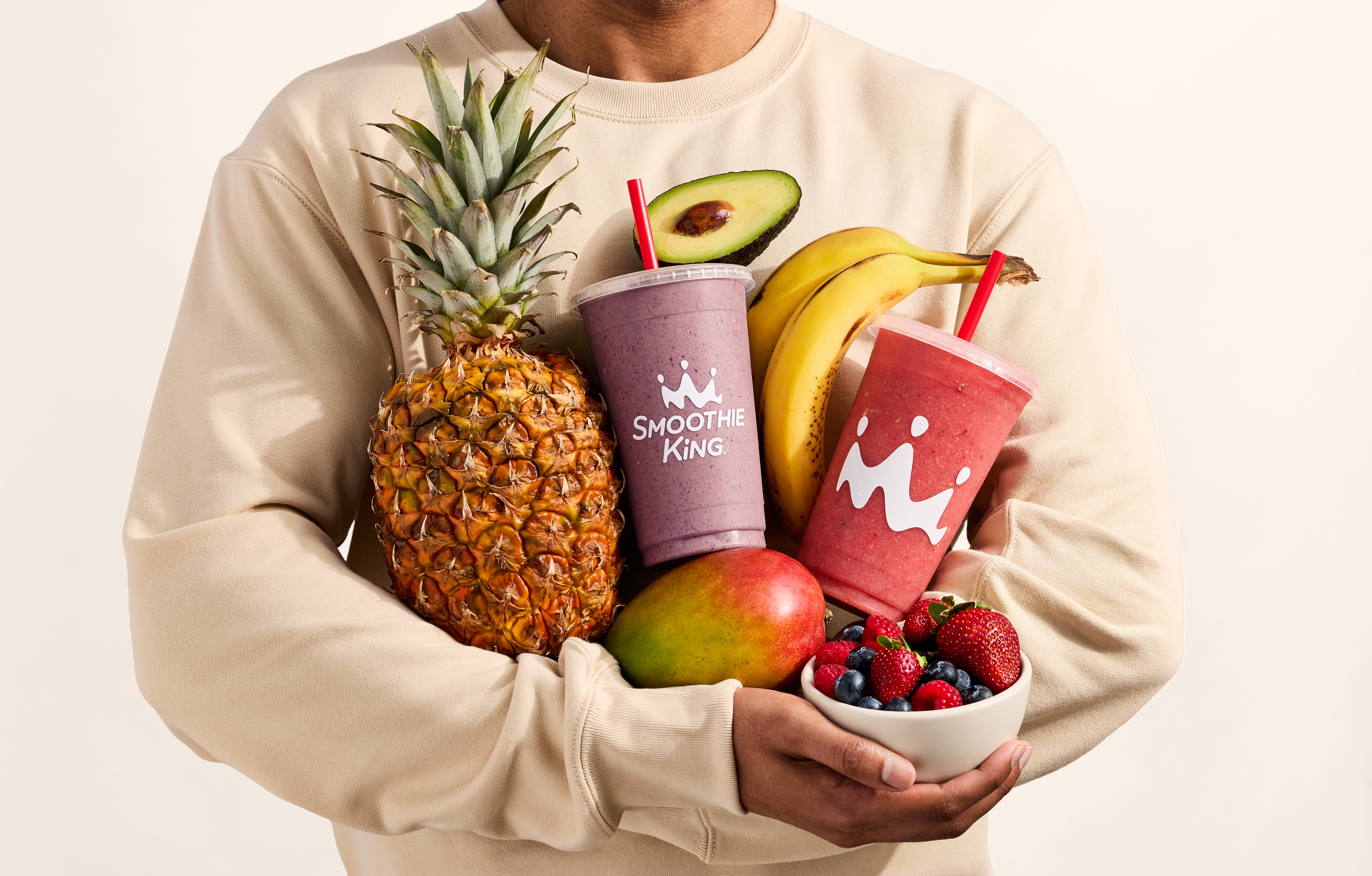 A man holding fruit and Smoothie King Smoothies