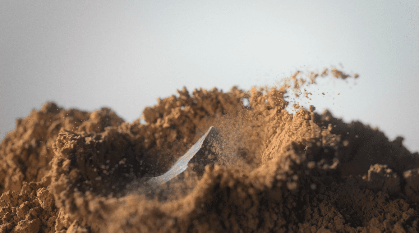 Chocolate falling into cocoa powder