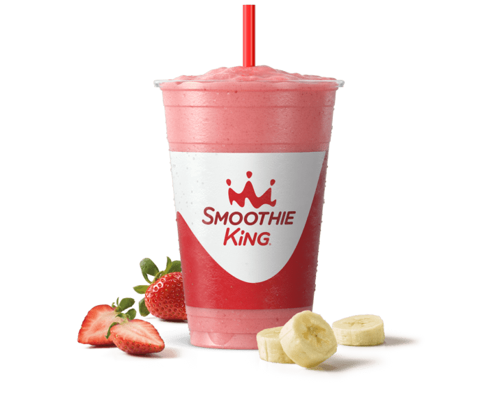 A pink strawberry banana smoothie in a Smoothie King cup with a red straw, part of Smoothie King history
